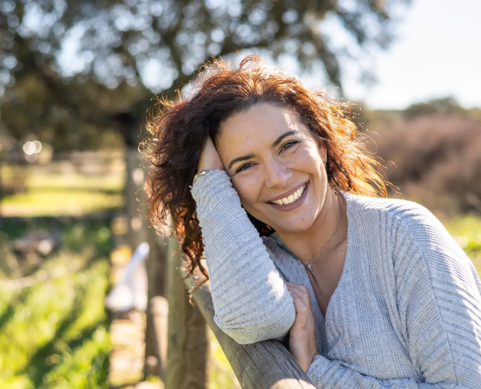 Smiling woman outdoors in a park – online psychiatry in Lansing, MI